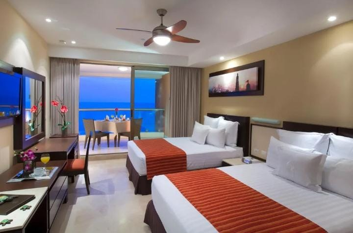 Habitación de hotel con dos camas y vista al mar