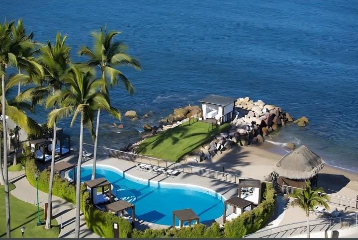 Piscina junto al mar con palmeras en Único Hotel Rivera Nayarit