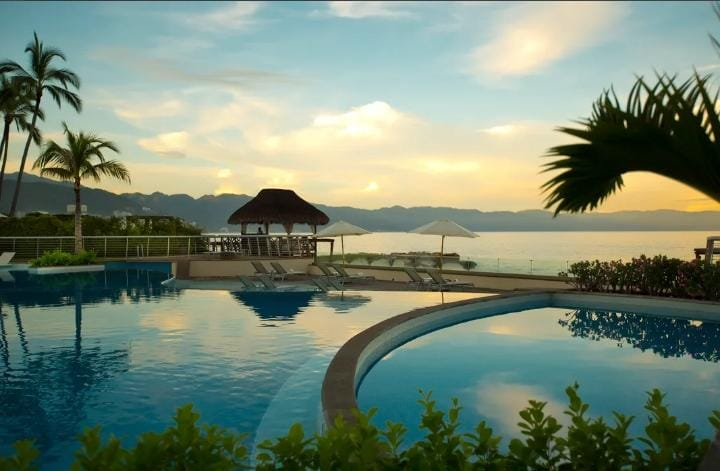 Piscina del hotel al atardecer junto a la costa