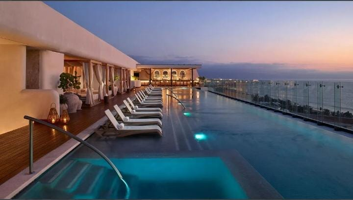 Piscina del hotel al atardecer junto al mar